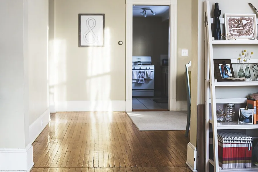 A bright, empty apartment hallway with wooden floors