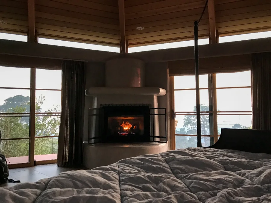 A living room with a fireplace and large windows