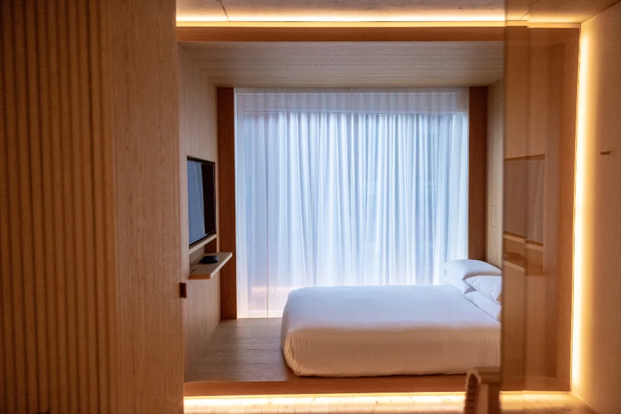 A tidy room with a made bed and soft lighting